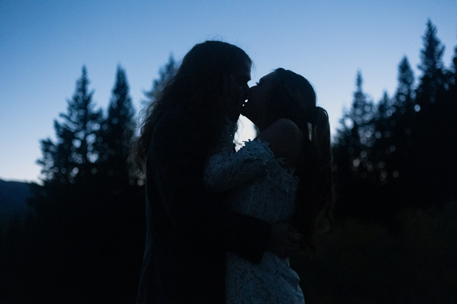 The silhouette of a couple kissing by moonlight as they elope in Colorado