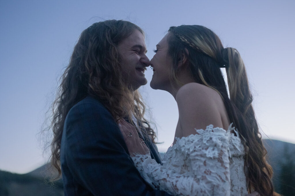 A couple with their noses touching as they smile. 