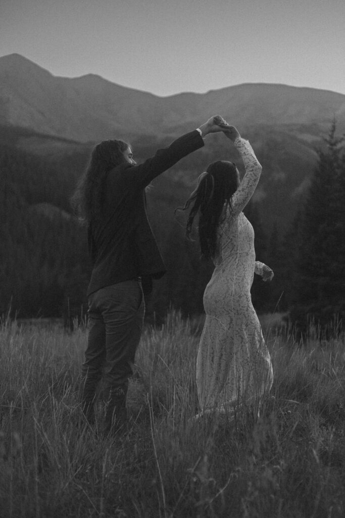 A wedding couple dancing in the mountains 