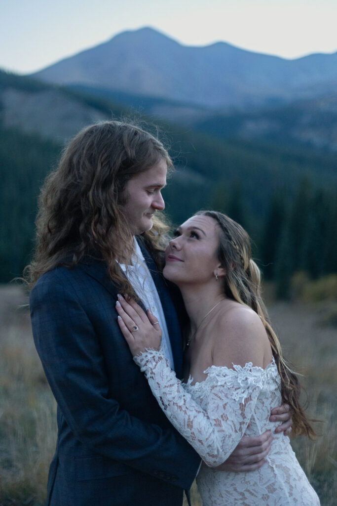 A person resting their head and hand on their partner's chest as they both smile