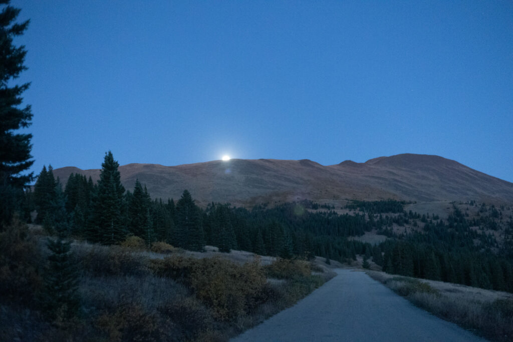 The moon shining over a mountain. 