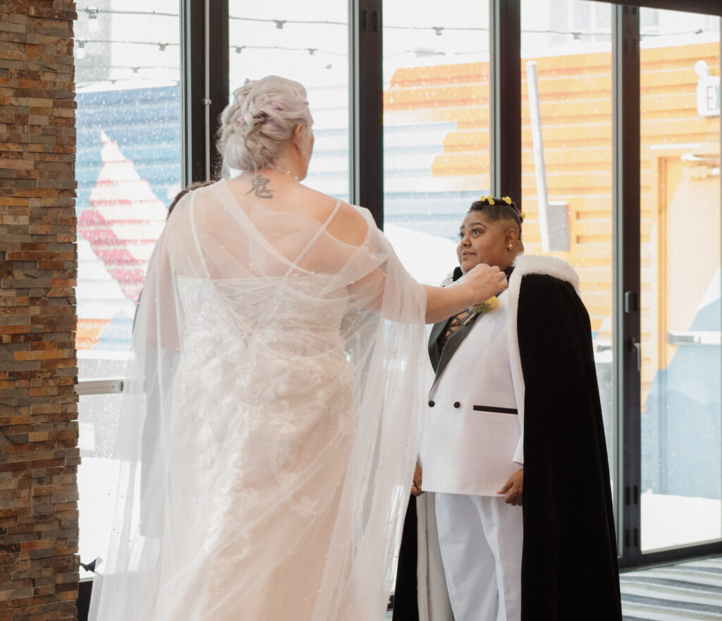 A person reaching out towards their partner's face on their wedding day. 