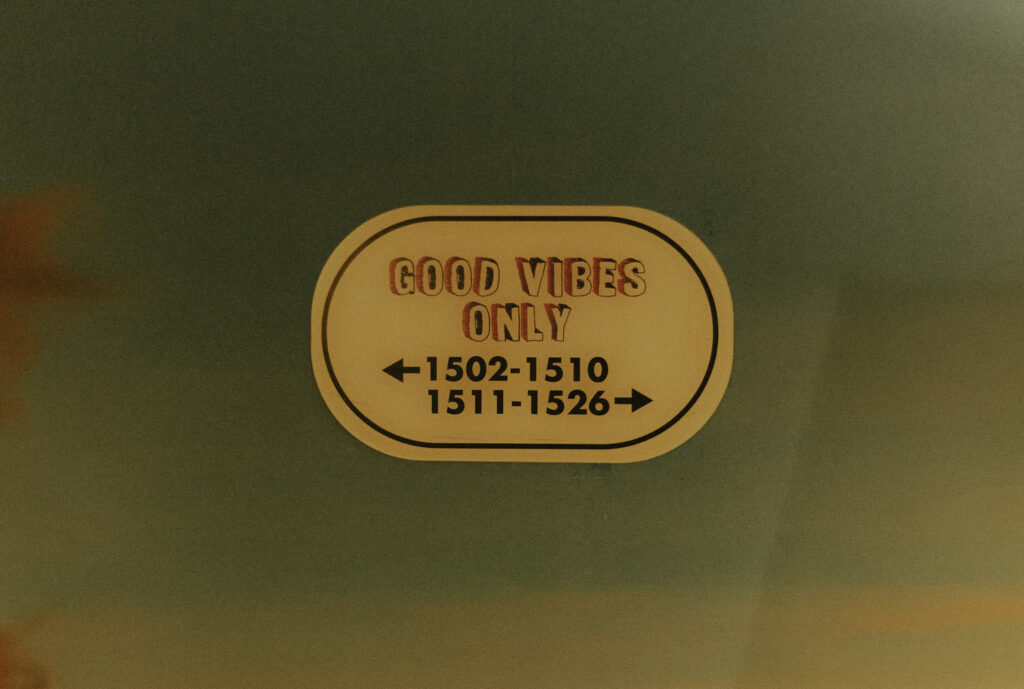 A hotel sign pointing towards rooms that says good vibes only
