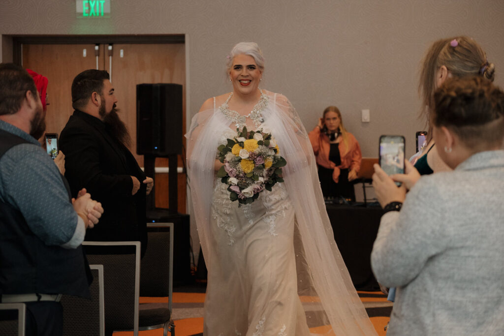 A person walking down the aisle holding a bouquet of flowers at their wedding. 