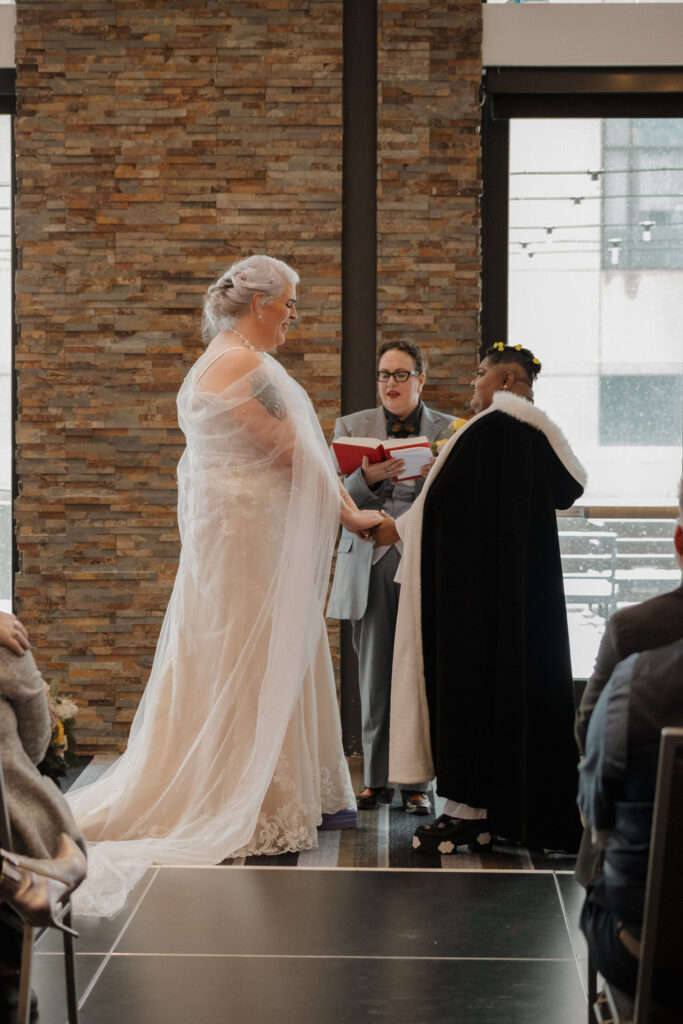 A couple standing up and saying their vows on their wedding day. 