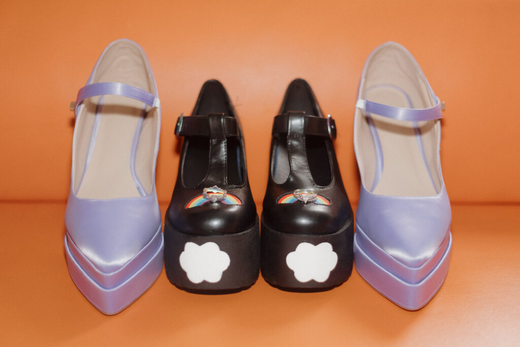 A pair of black shoes with purple shoes on either side and rings on top of them. 