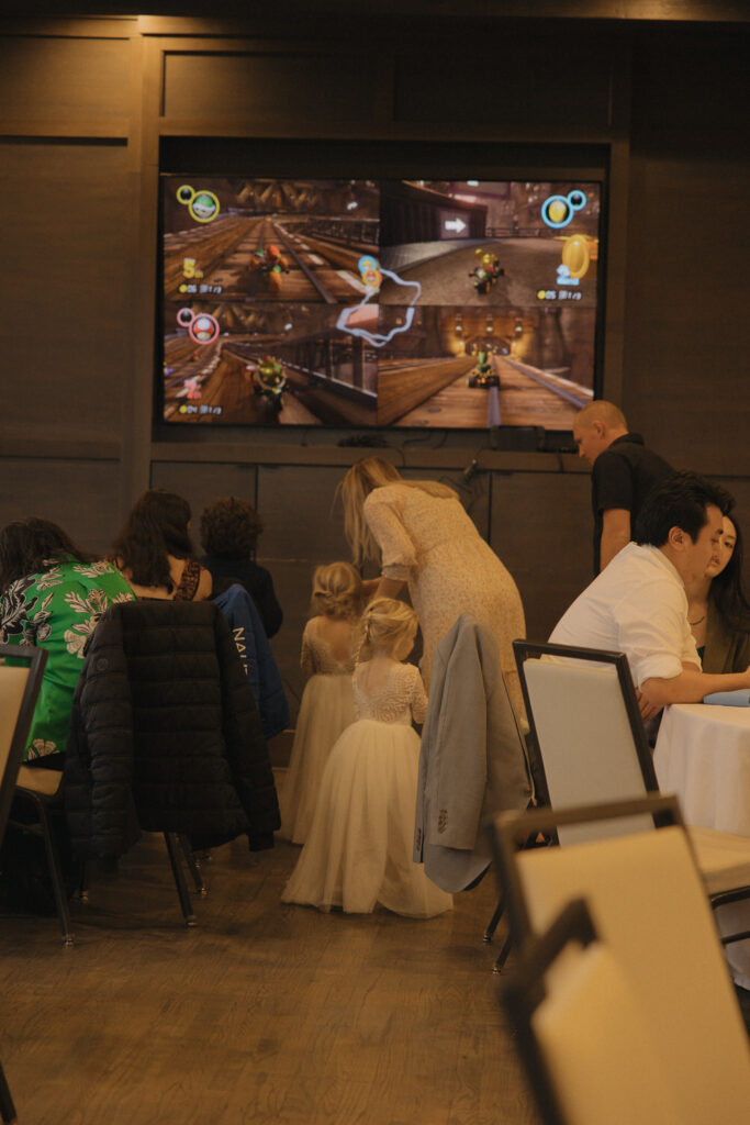 Mario cart being played at a wedding reception. 