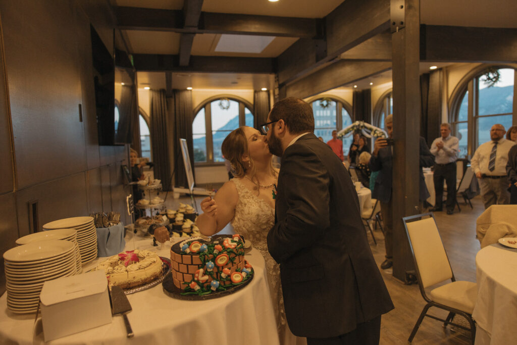 A newlywed couple kissing after cutting their wedding cake