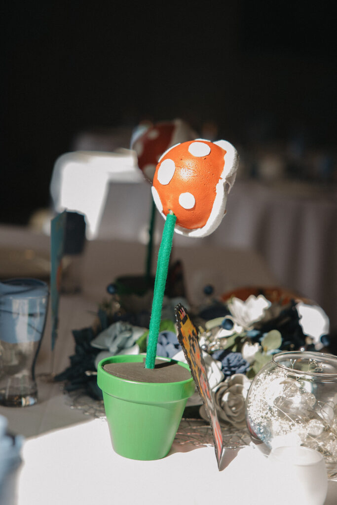 A Mario themed flower sticking out of a green pot. 