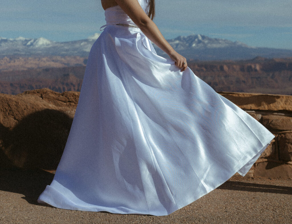 A person swinging the bottom of their wedding dress. 